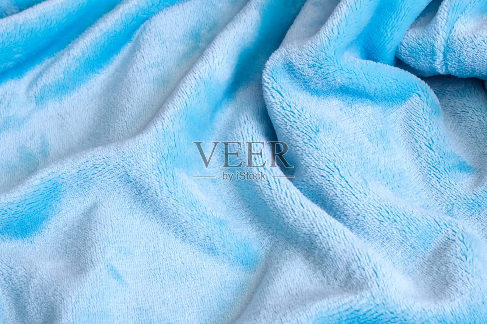 蓝色天鹅绒织物上的褶皱近距离照片摄影图片