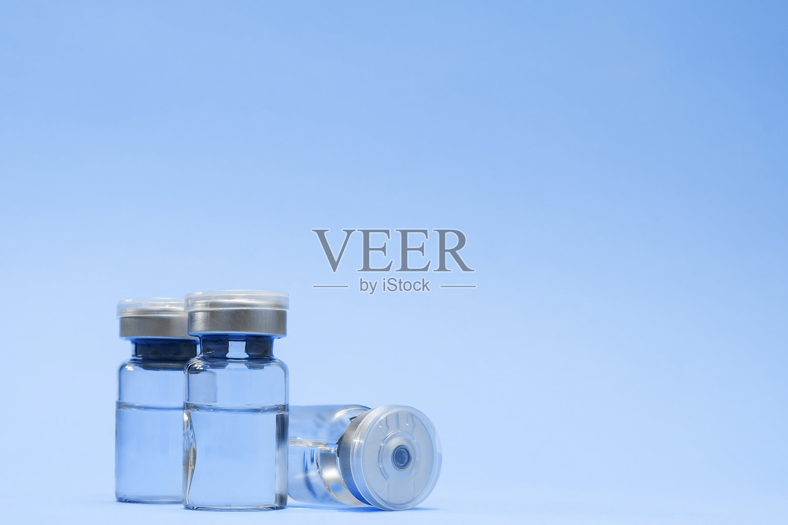 安瓿,小瓶,蓝色背景。接种疫苗概念,预防疾病。医疗保健、冠状病毒疫苗开发。文本空间照片摄影图片