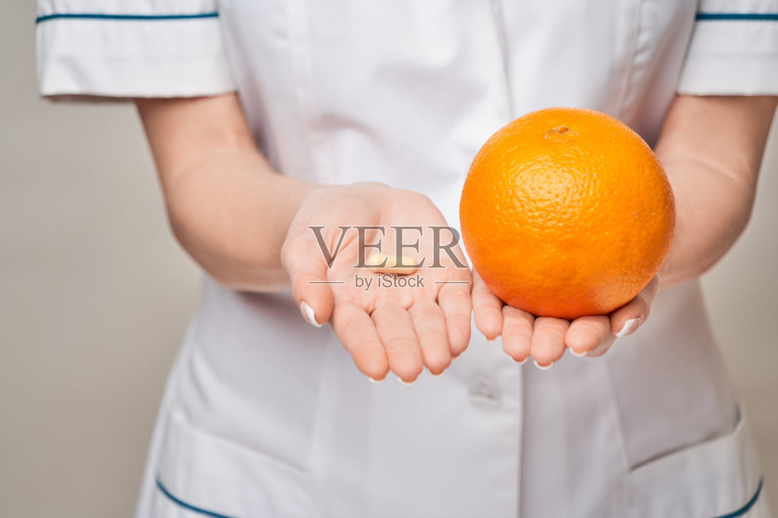 营养学家医生健康生活方式概念-持有橘子水果和营养维生素胶囊或药丸照片摄影图片