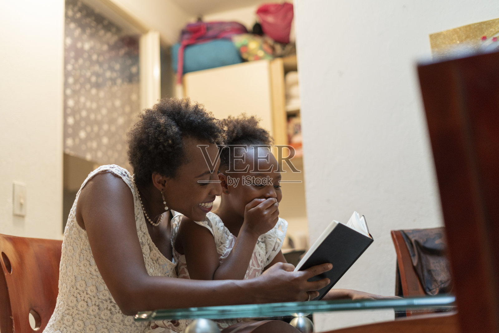 在宁静的家中,母亲给她7岁的女儿读了一本美丽的书,两人享受着这一刻照片摄影图片