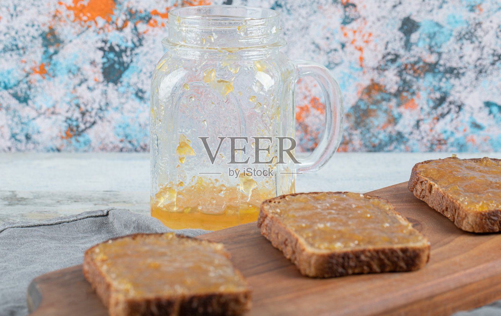 涂着桃酱的黑面包片放在木砧板上照片摄影图片