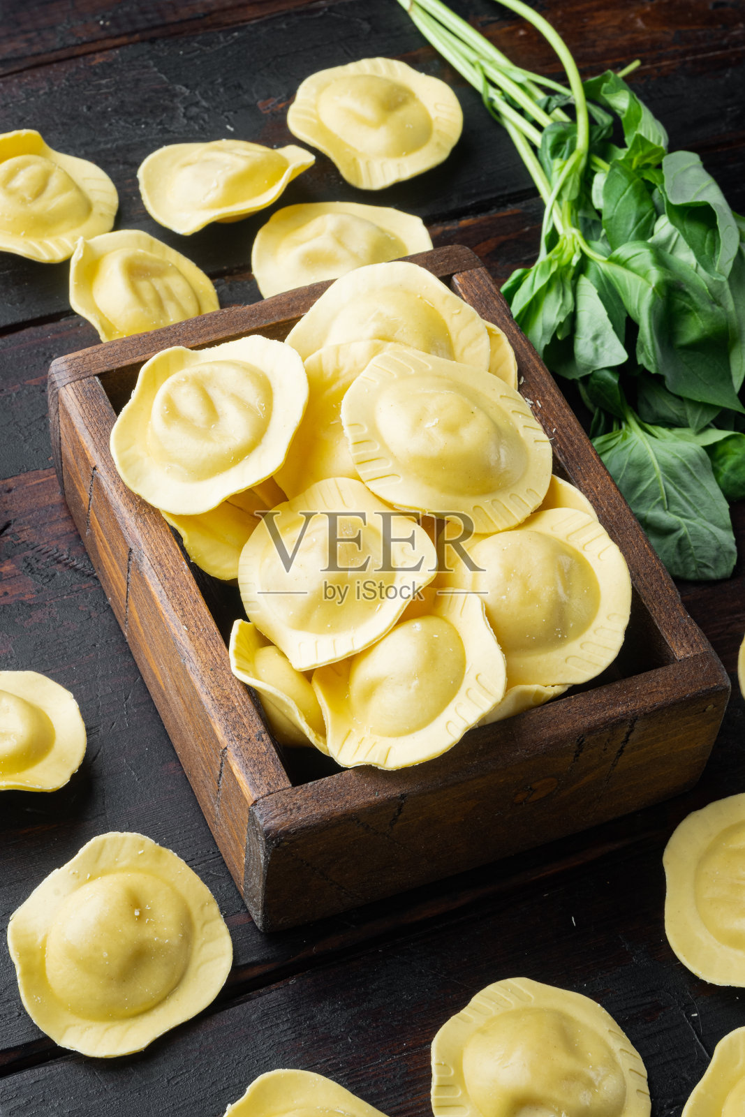 木盒里的自制罗勒和番茄馄饨,背景是旧的深色木桌照片摄影图片