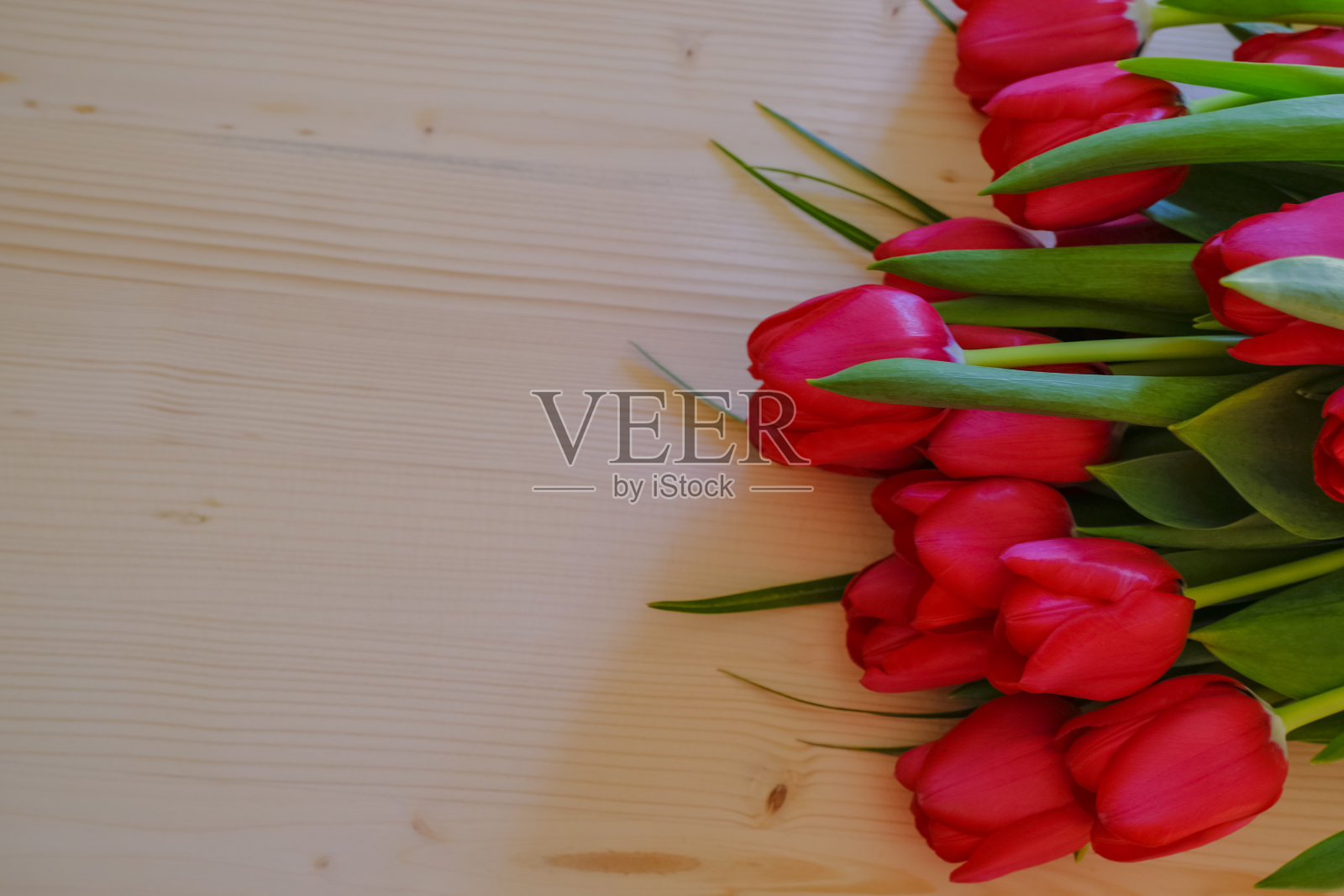 木质背景上的红色郁金香花束。前视图。副本的空间。植物的模型。美丽、风格、时尚平躺照片摄影图片