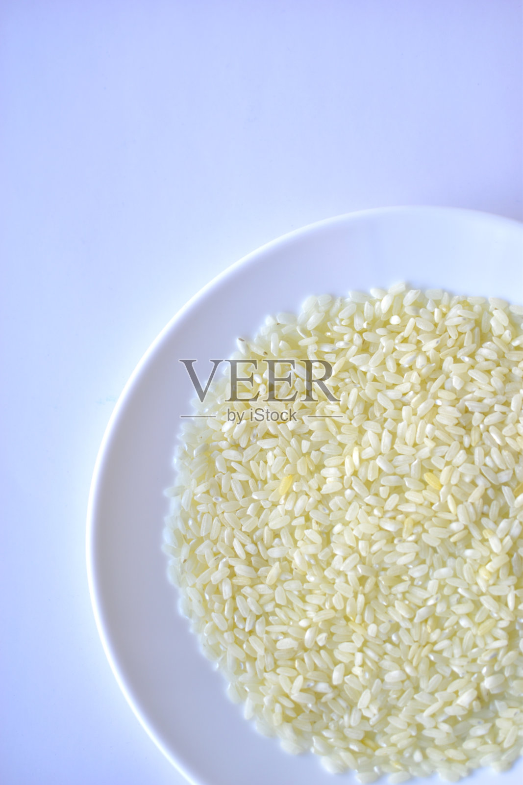 白色的盘子里放着黄色的米粒照片摄影图片