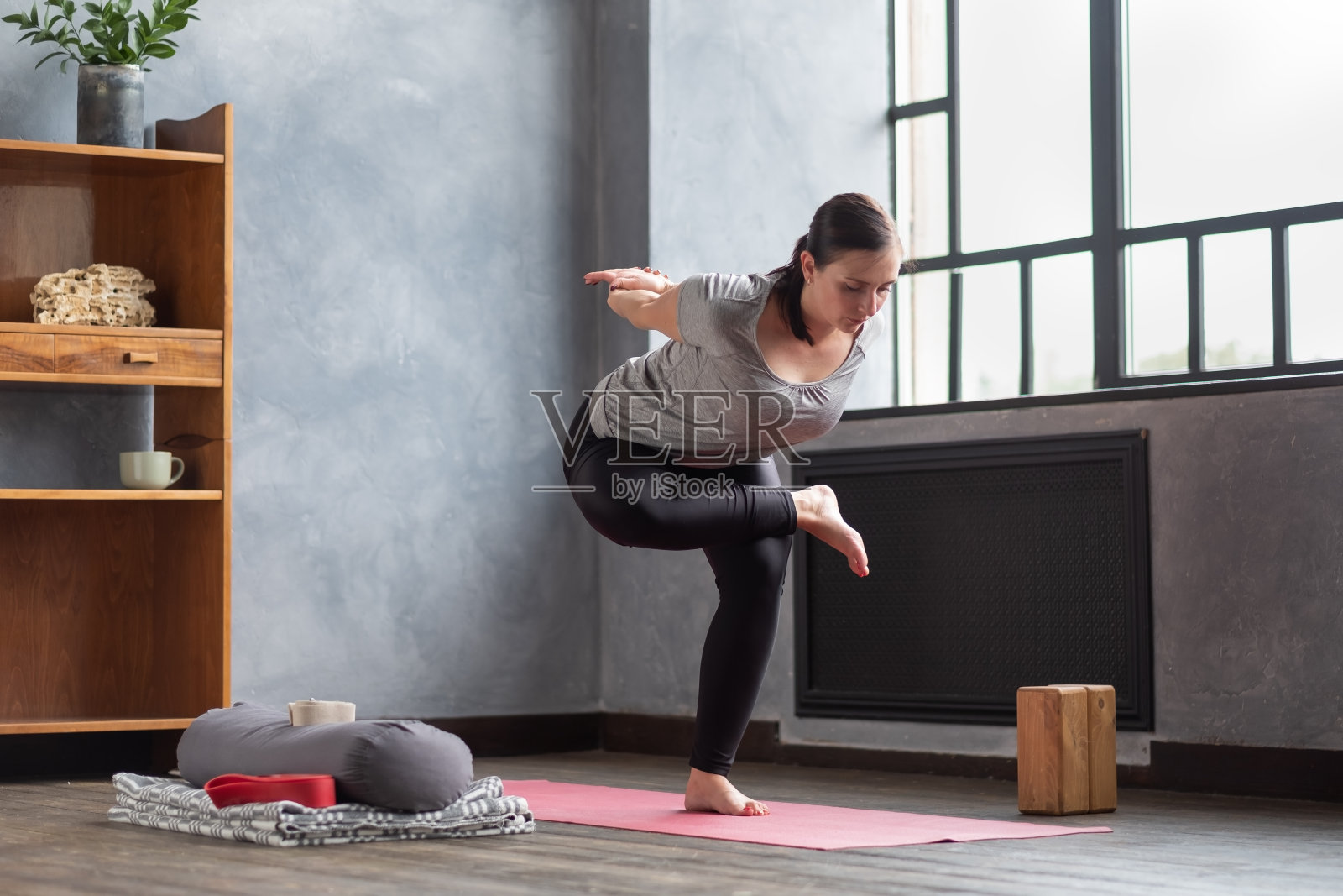年轻女子练习瑜伽,站在鹰练习,鹰式体式照片摄影图片