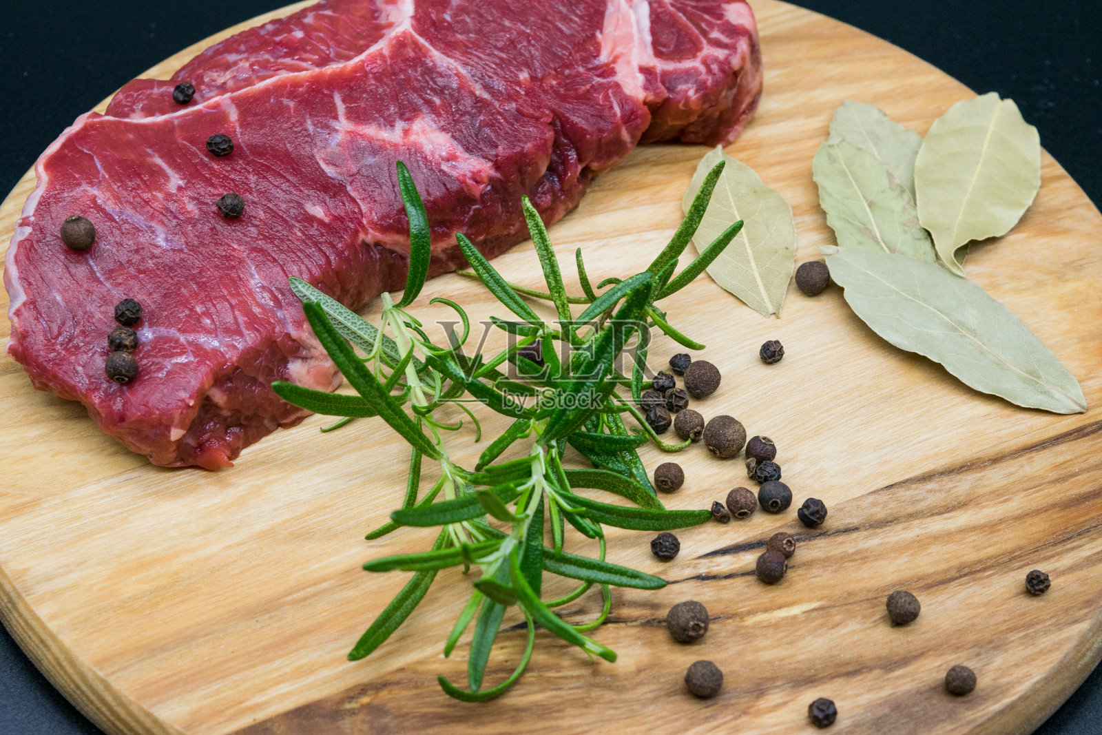 牛排,新鲜牛肉放在木板上,配上迷迭香,黑胡椒,厕叶照片摄影图片