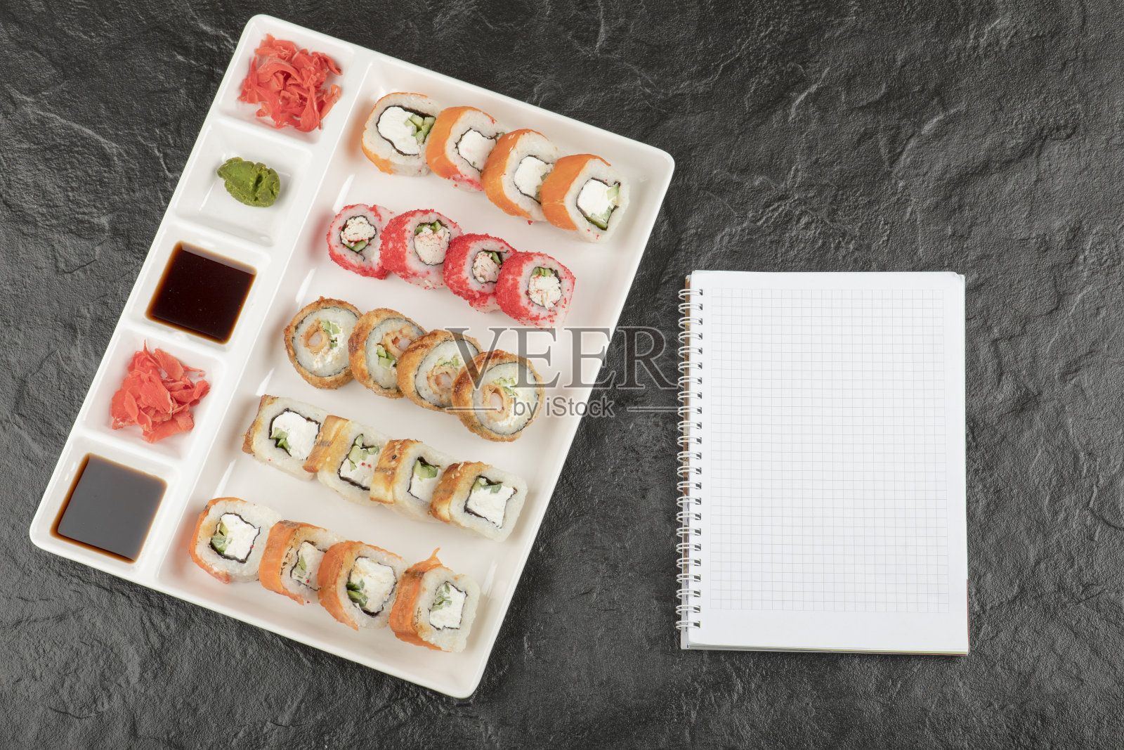 一块白板,上面有不同种类的美味寿司卷照片摄影图片