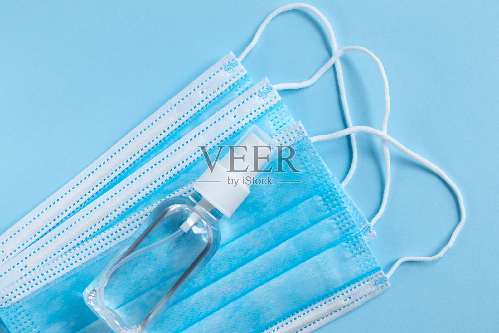 带外科口罩的酒精洗手液凝胶瓶。照片摄影图片