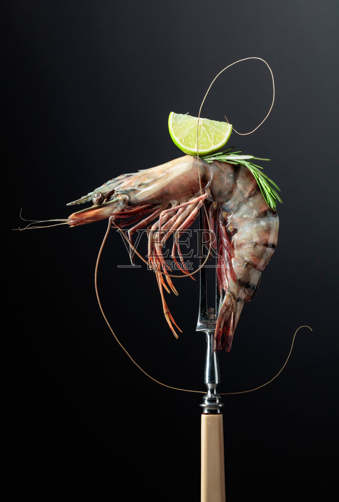鲜虎虾,迷迭香和青柠片,黑色背景。照片摄影图片