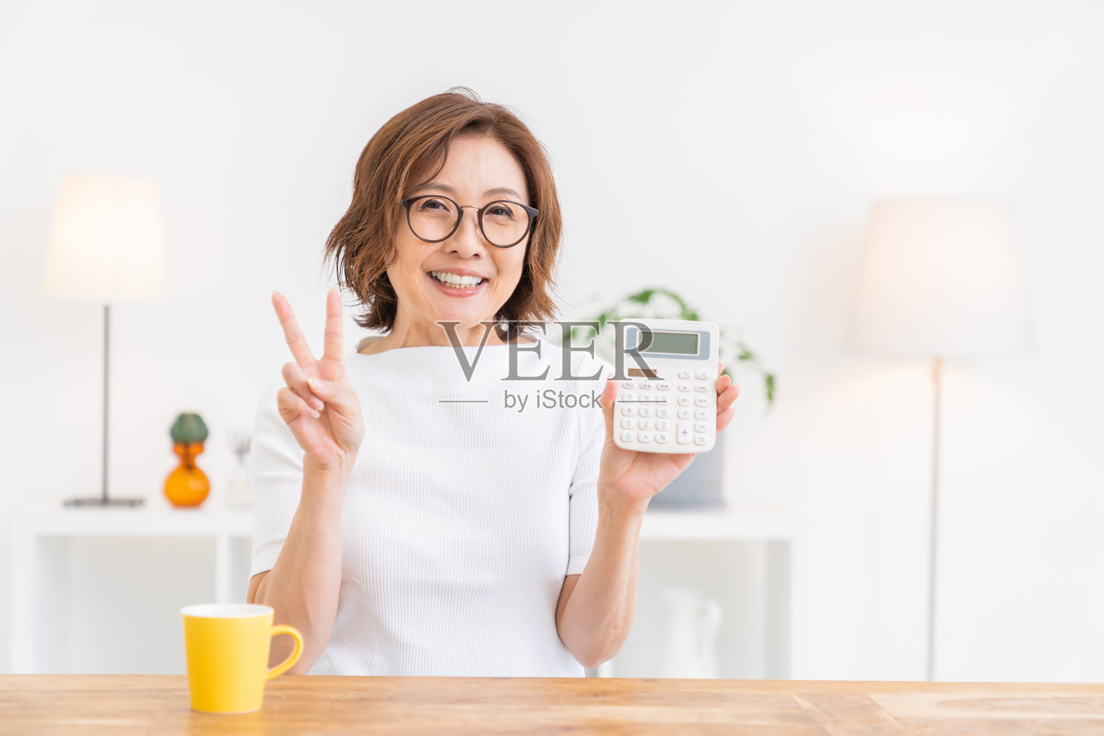 老年妇女有一个电子计算器,微笑照片摄影图片