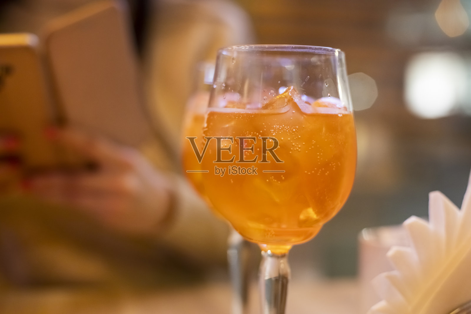 在夕阳的照耀下,咖啡馆的一张木桌上放着两杯葡萄酒。意大利的一种含桔子和冰的酒精饮料。特写,有选择性的重点,照片摄影图片