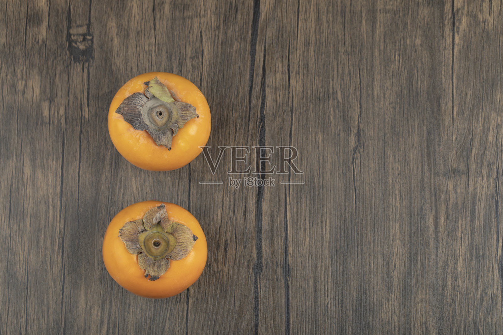 两个熟柿子放在木板上照片摄影图片