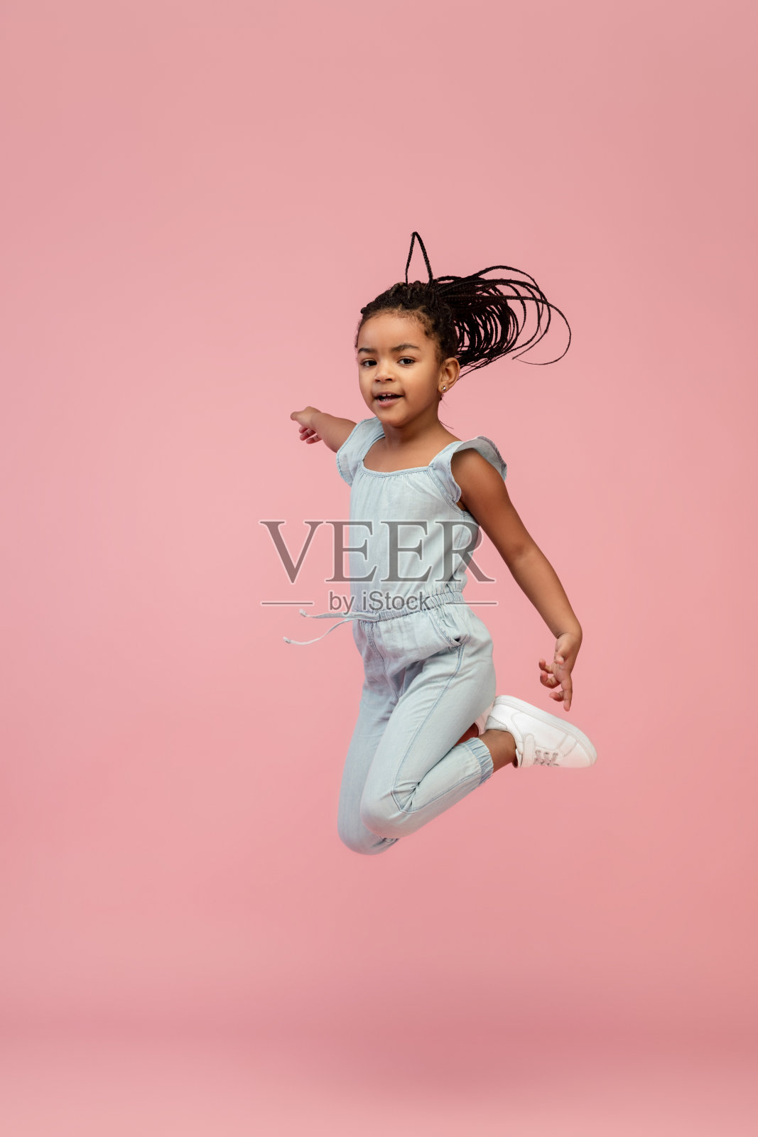 快乐的长发黑发小女孩孤立在粉红色的工作室背景。看起来开心,开朗,真诚。Copyspace。童年,教育,情感概念照片摄影图片