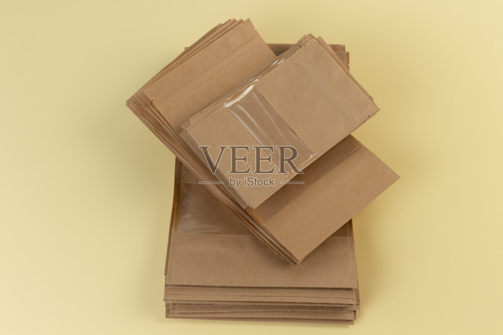 棕色牛皮纸doypackbag与杂货前视图上的黄色背景。食品和商品的包装模板模型。包装带窗户,用于重量产品。照片摄影图片