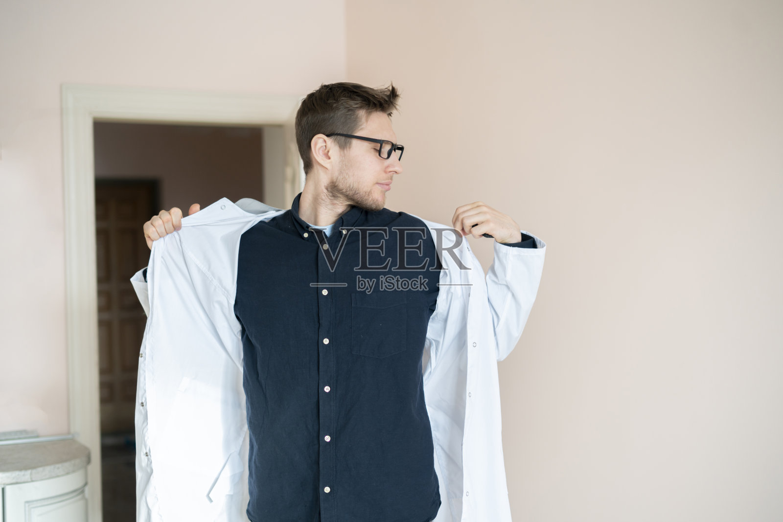 男医生在医院穿上医袍制服,门诊年轻专科医生照片摄影图片