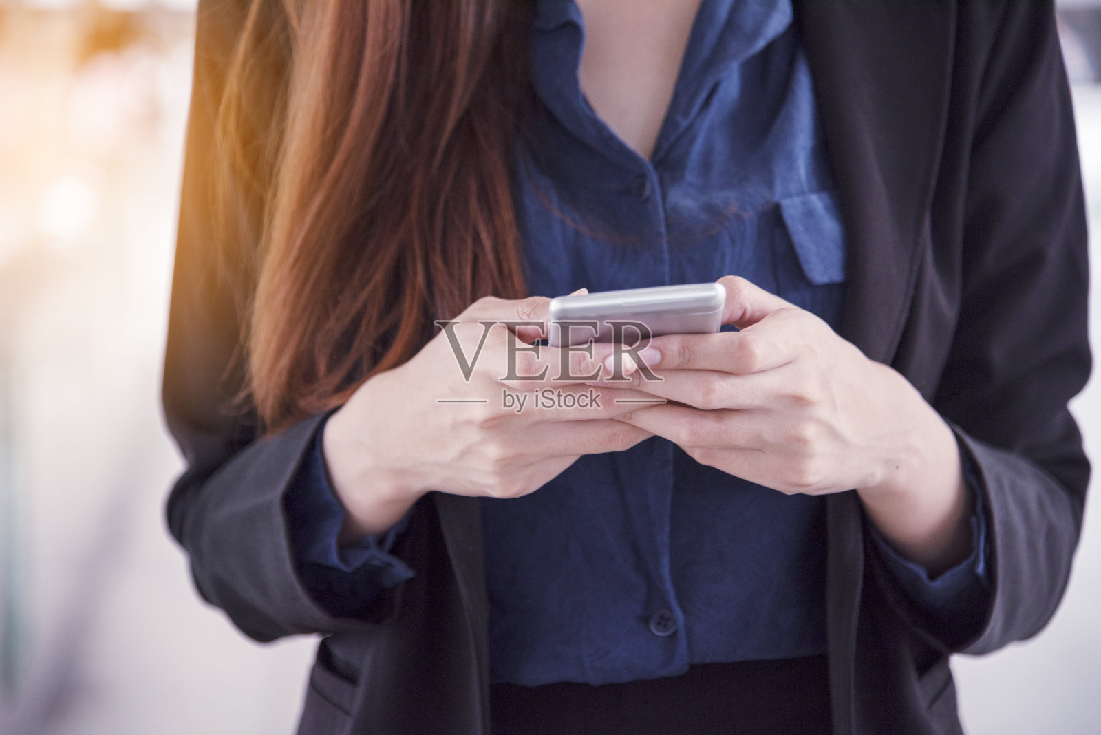 商业女性使用智能手机在线购物,打电话,短信互联网技术的生活方式。一名亚洲女性在城市街道上使用手机。智能手机智能自信女人现代都市照片摄影图片