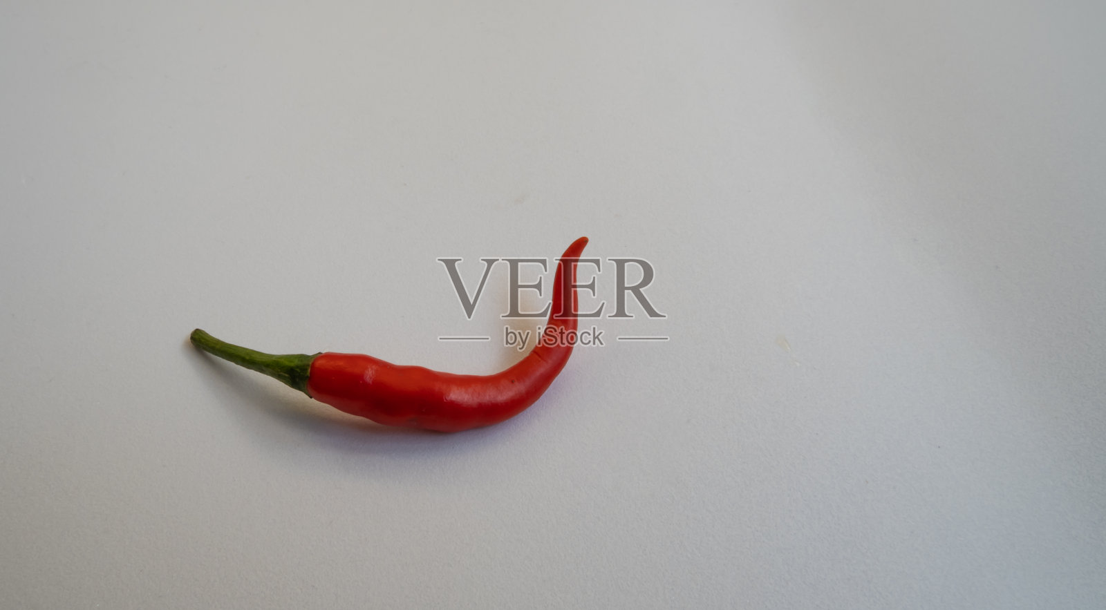 鲜红的辣椒有一个漂亮的弯。照片摄影图片