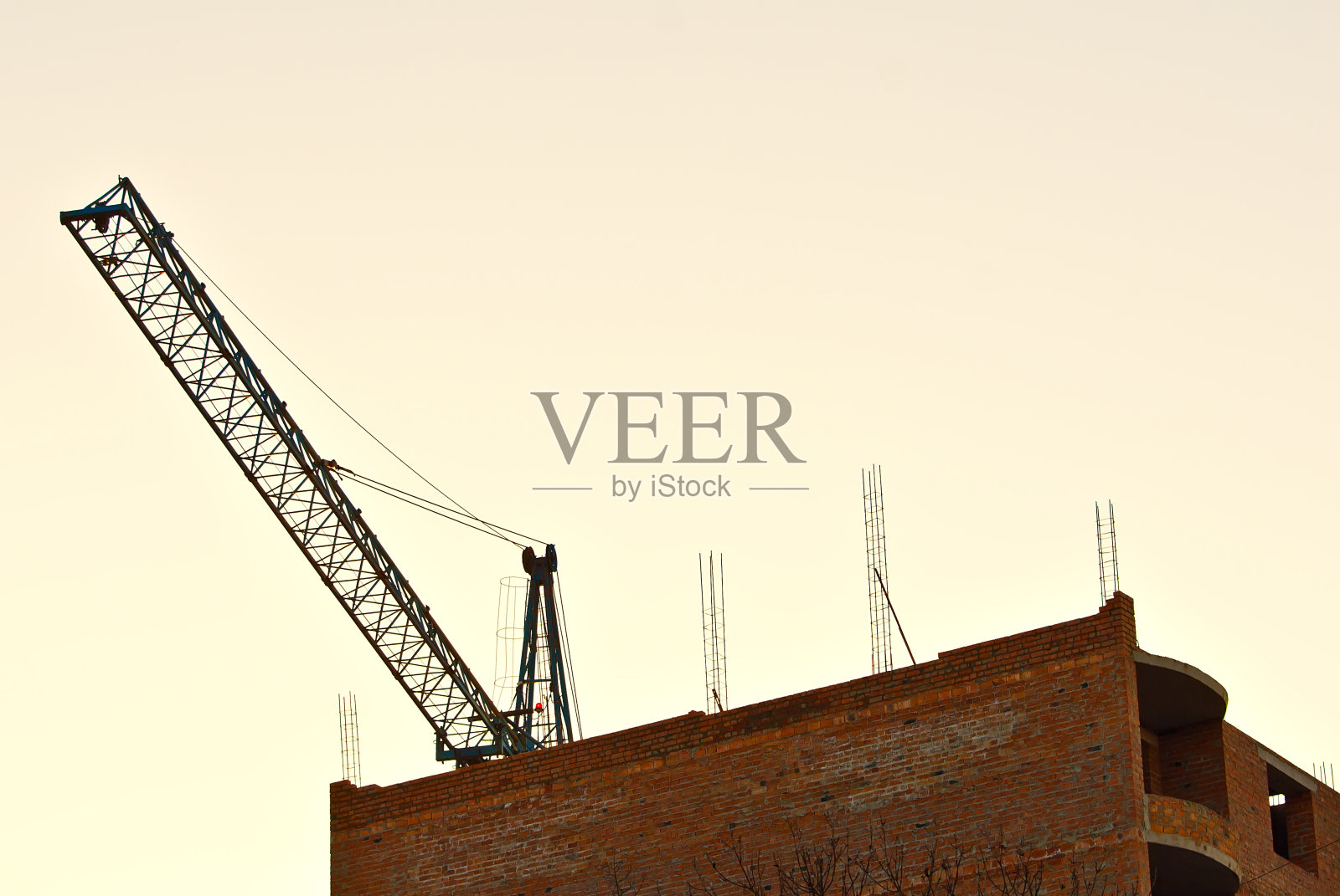 日落背景上一只鹤的剪影。橙色背景上的绳子和钩子。照片摄影图片