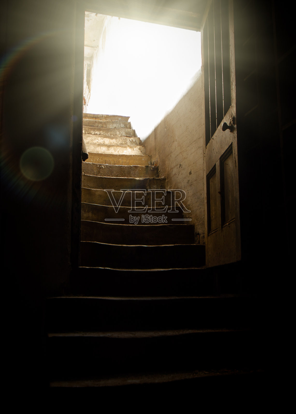古老的木门进入地下室,光线从石头破旧的楼梯照进黑暗的地下室,破败的阴影和黑暗。照片摄影图片