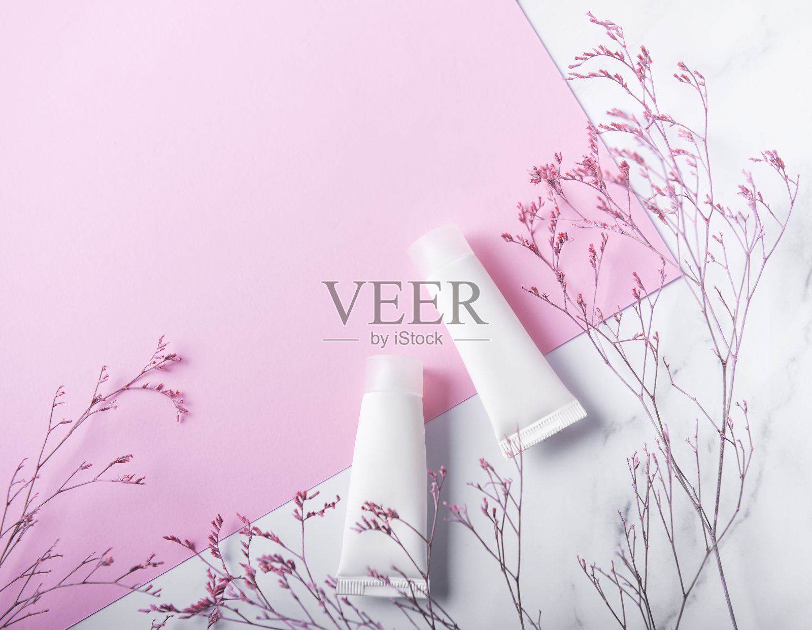 大理石和粉红色背景上的白色奶油管照片摄影图片