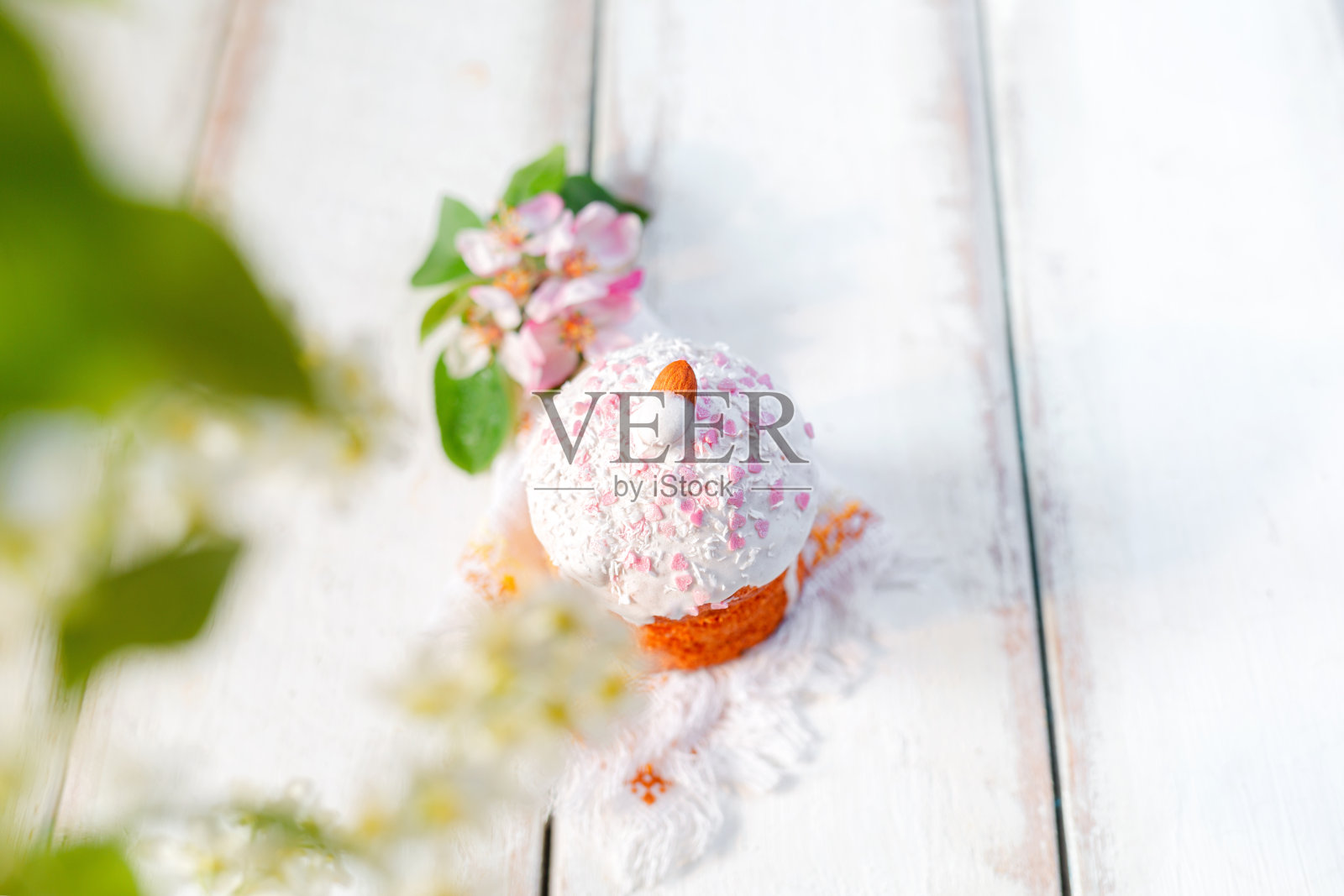 一个用苹果花和樱桃枝装饰在餐巾上的复活节蛋糕。前视图。复活节假期。本空间照片摄影图片