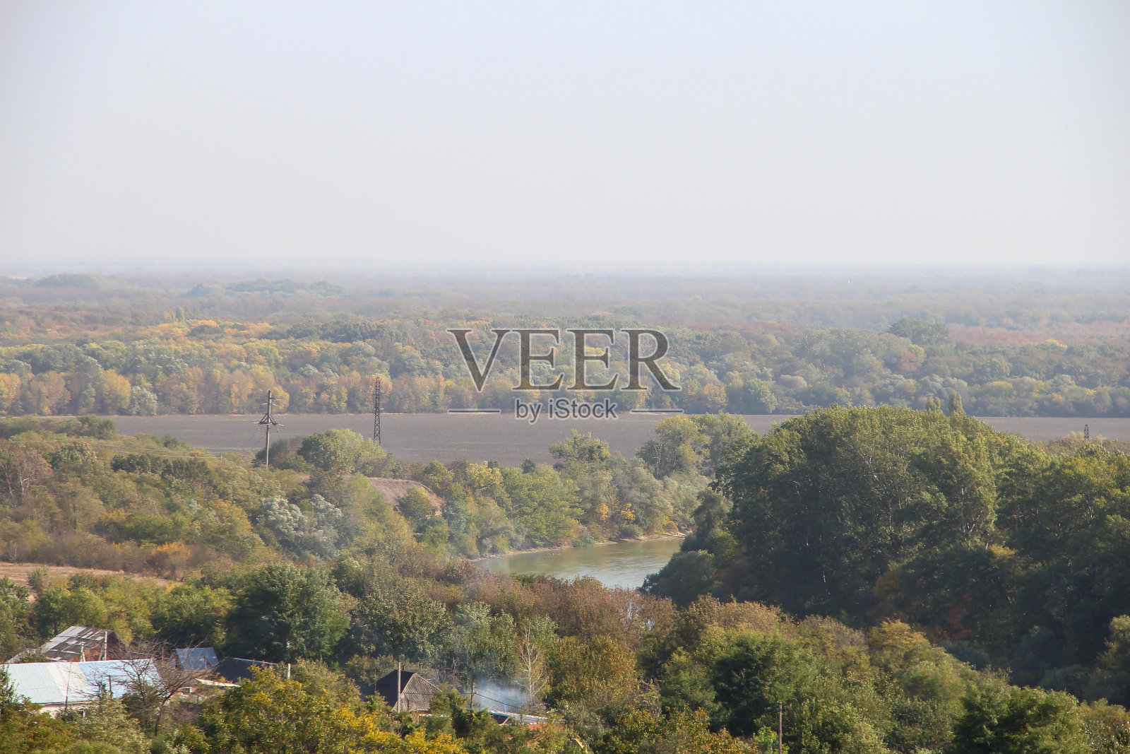 山下有河流、树木和村庄照片摄影图片