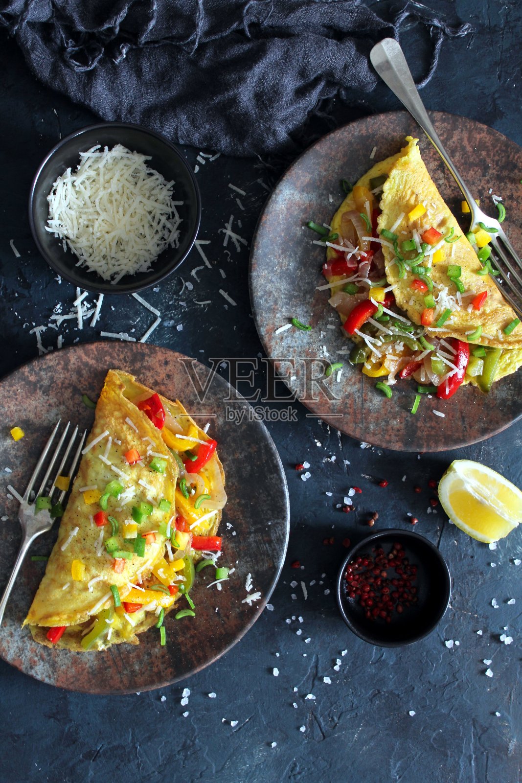 健康的早餐:黑色背景的塞满蔬菜的煎蛋卷。照片摄影图片