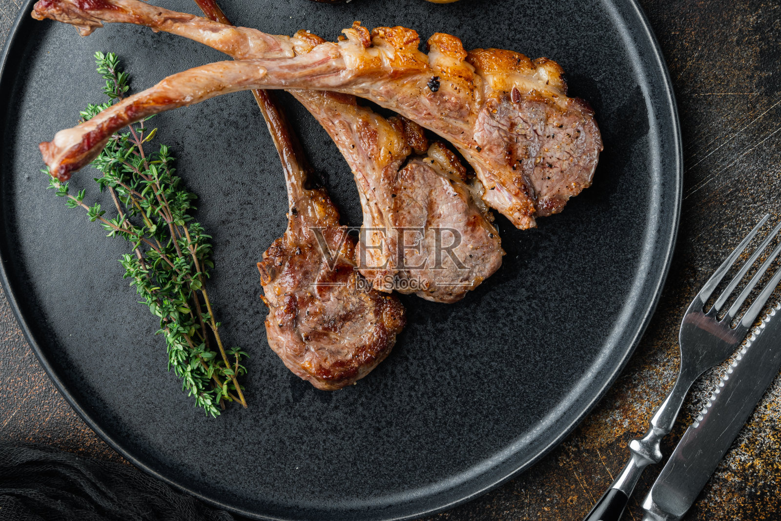 烧烤晚餐。烤羊肉排与洋葱和百里香,在盘子上,在老的黑暗乡村背景,俯视图平lay照片摄影图片