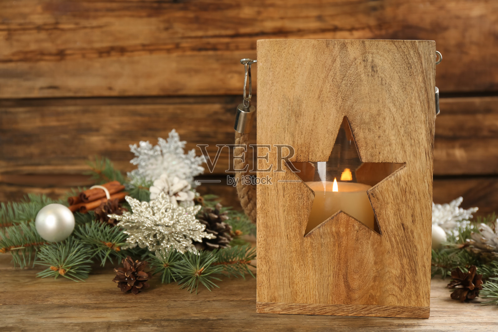 圣诞灯笼与燃烧的蜡烛和节日装饰木制桌子。空间的文本照片摄影图片