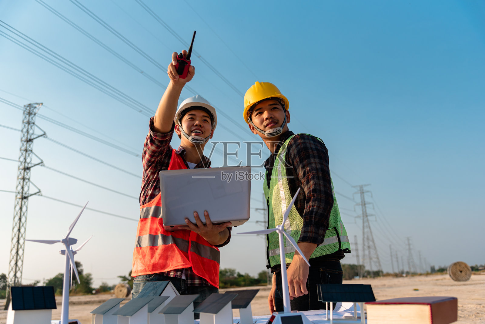 工程师与工头商议太阳能发电厂的安装计划。工程师在施工现场与工头讨论。照片摄影图片
