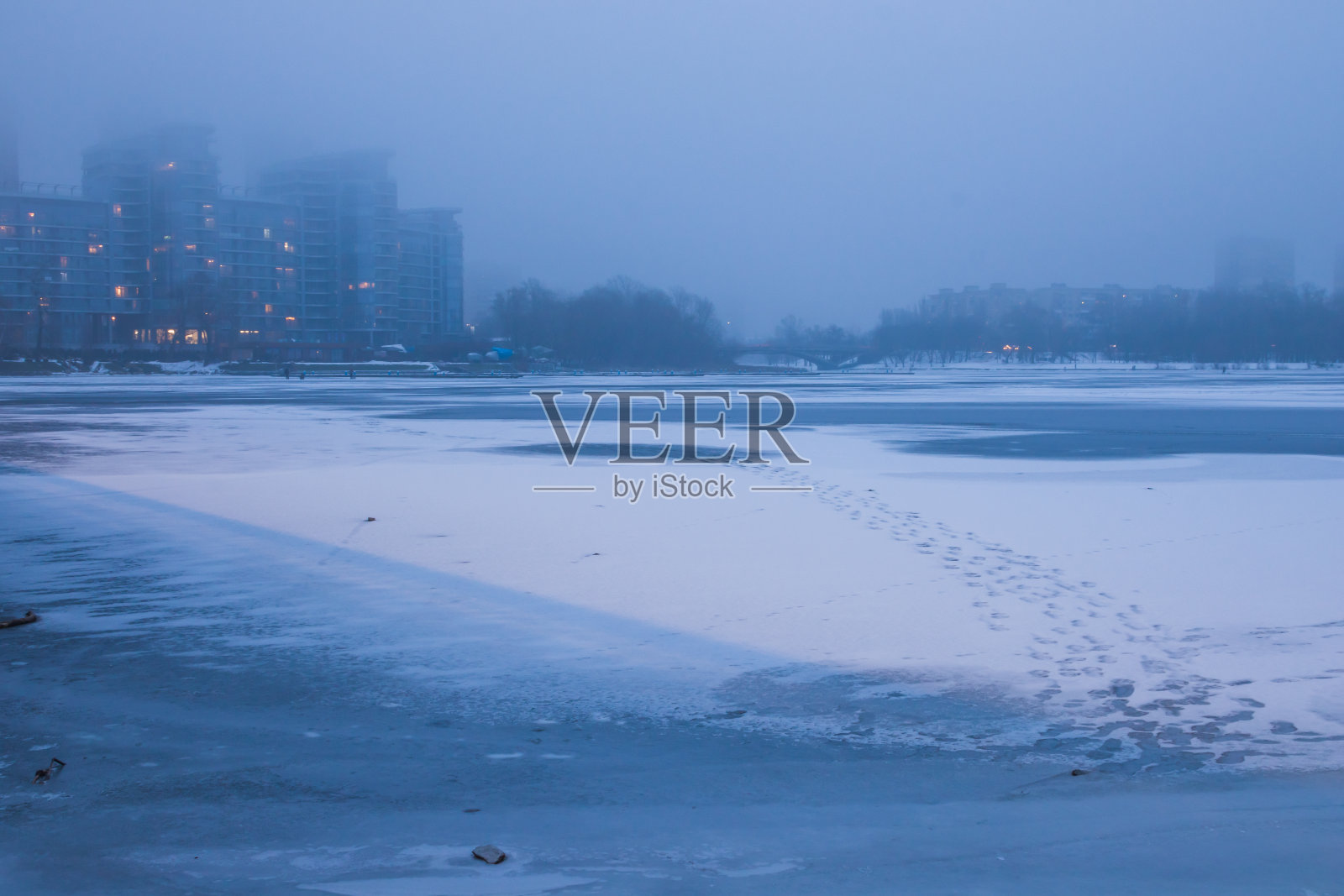 冬天的风景。阴天结冰的河上有雾。河岸边的高楼在雾中。Dnipro。基辅,乌克兰照片摄影图片