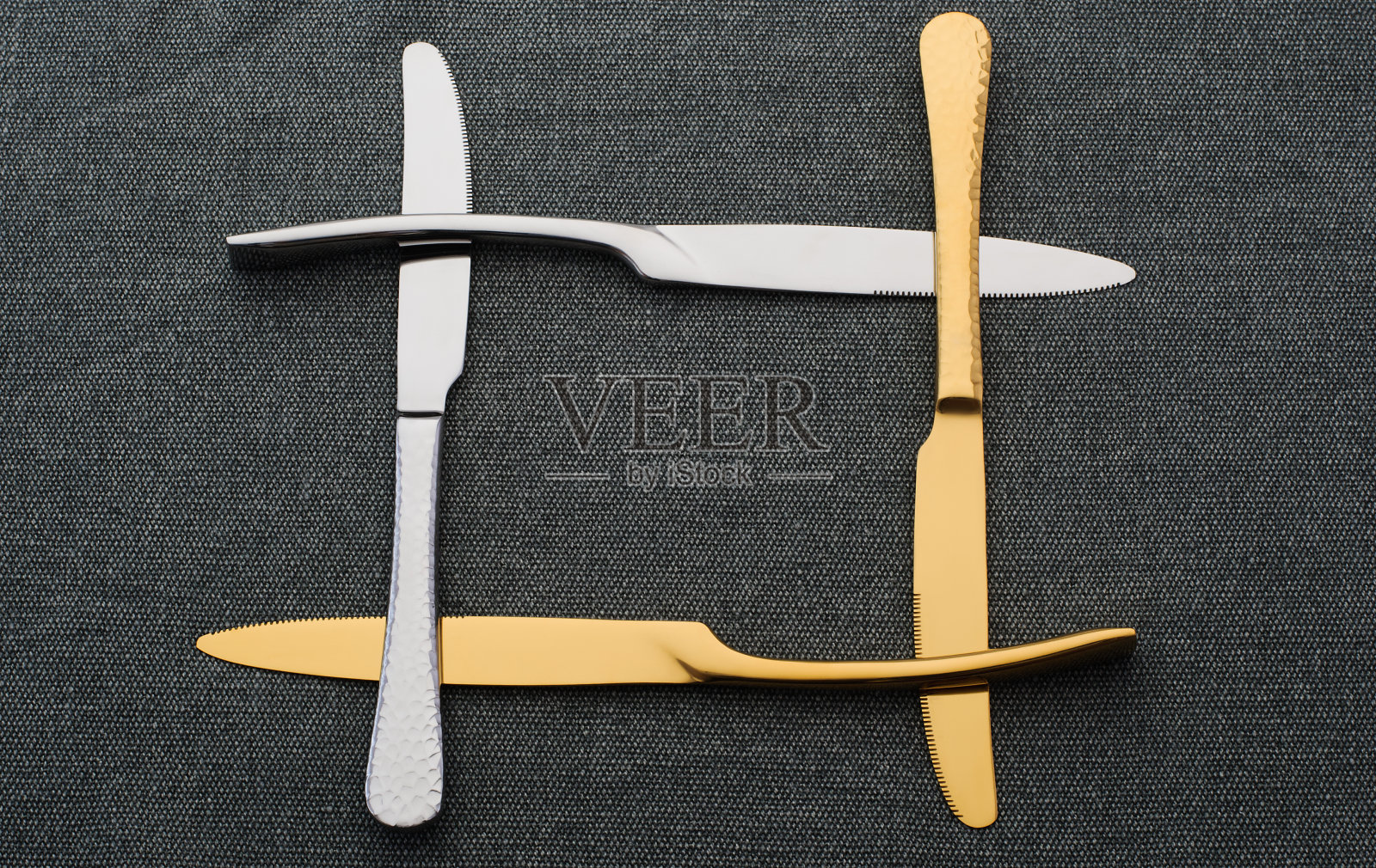 金色和银色的刀架放在深色的桌布上。一套金属刀照片摄影图片