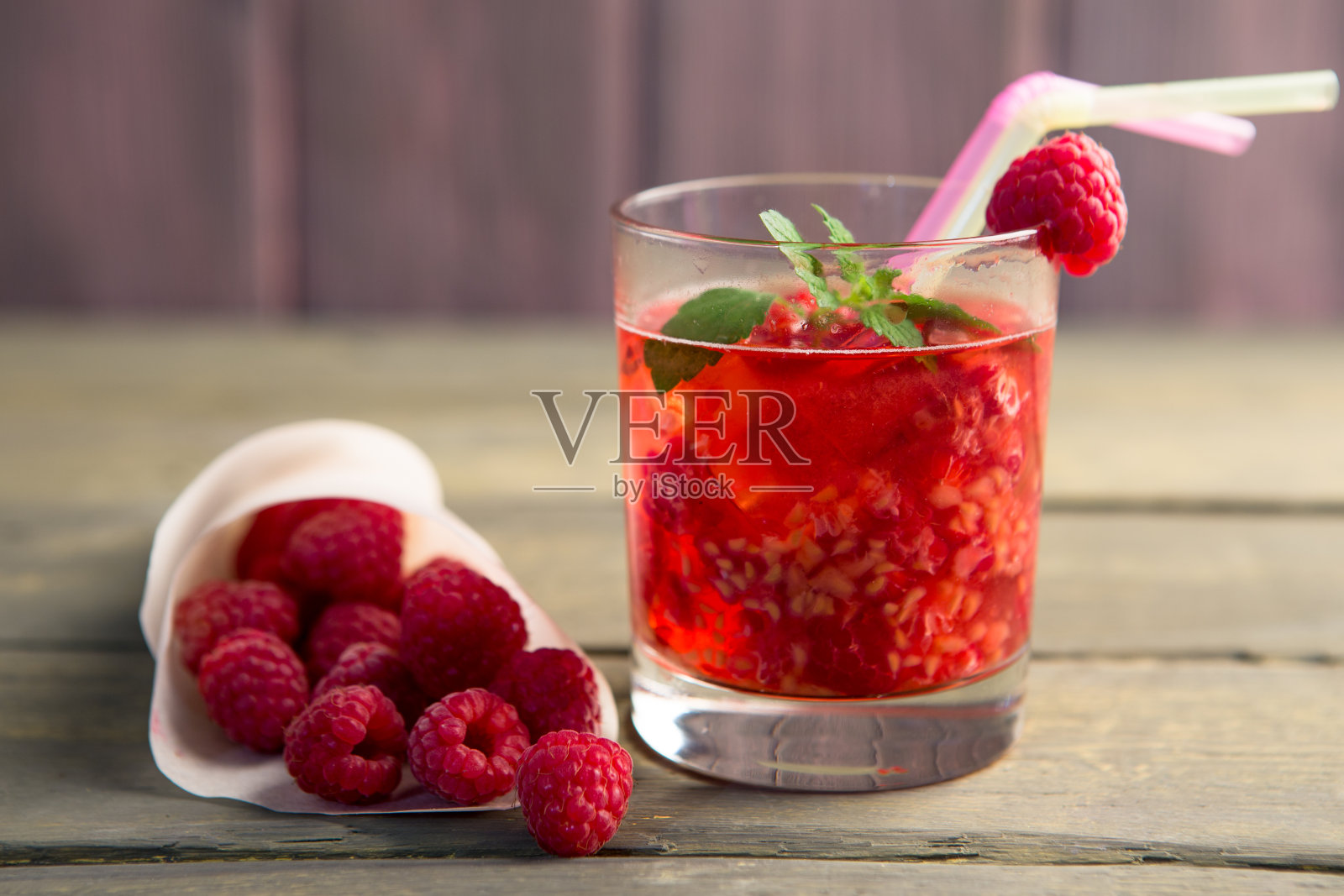 一杯新鲜的草莓冰沙和新鲜的草莓在粉红色的木制背景。健康饮食理念。照片摄影图片