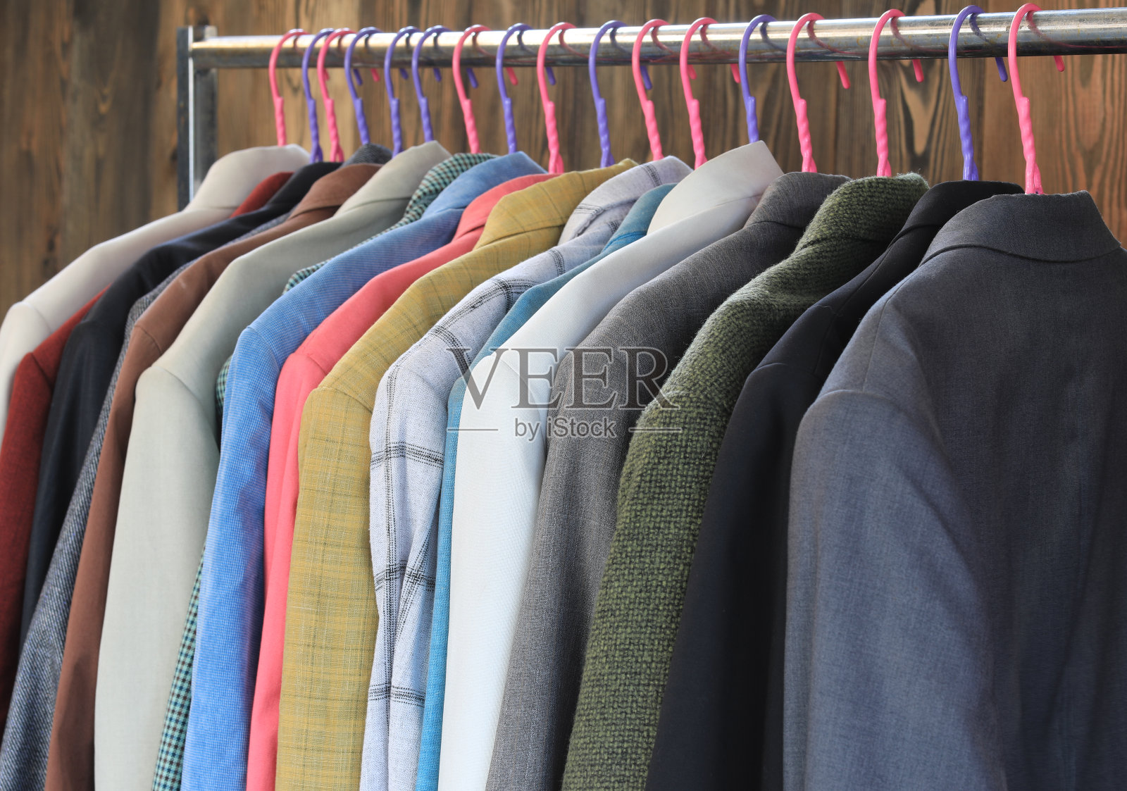 挂在衣柜衣架上的一套彩色西装外套照片摄影图片