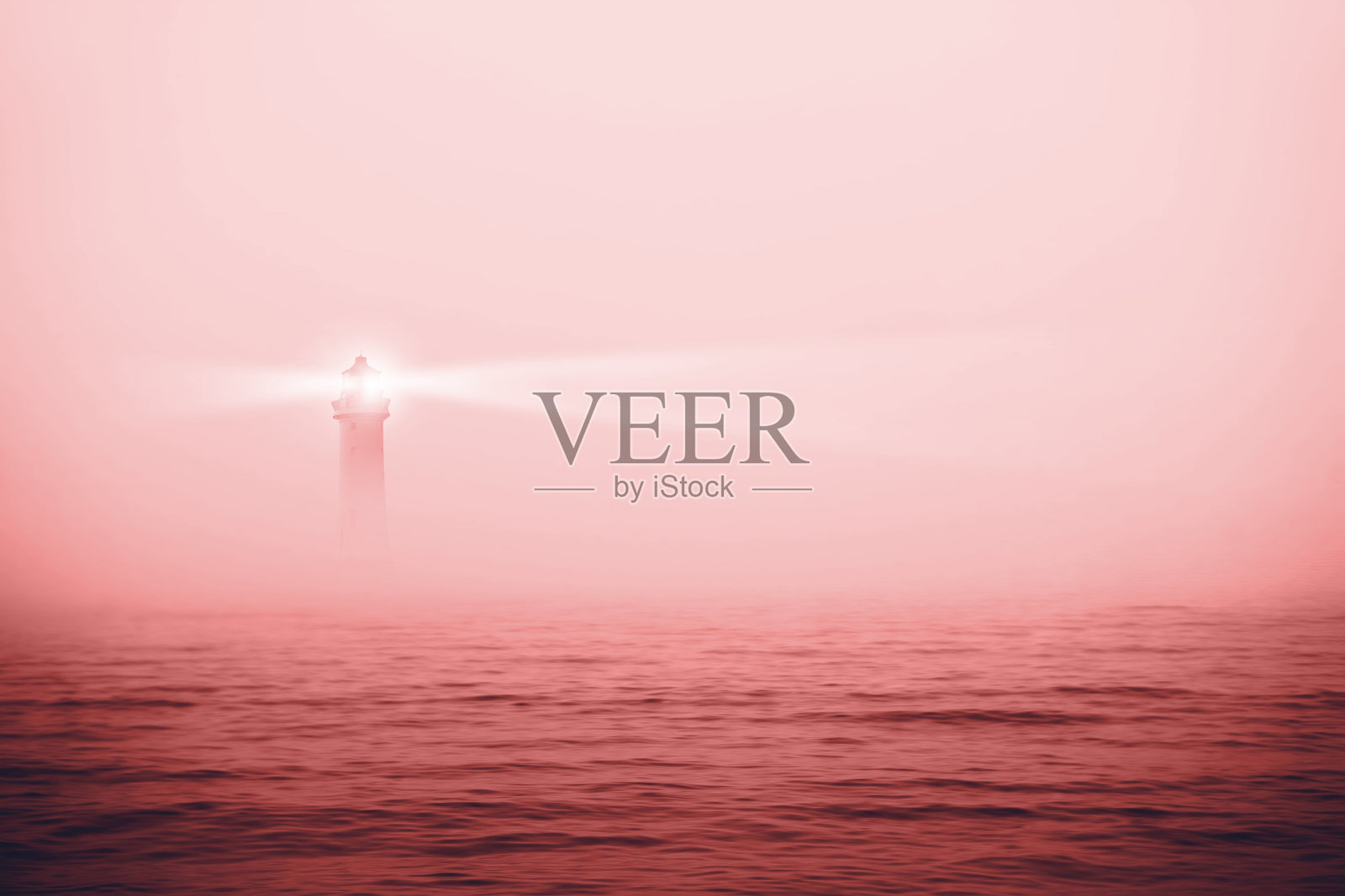 雾海中孤独的灯塔。2021年的珊瑚色照片摄影图片