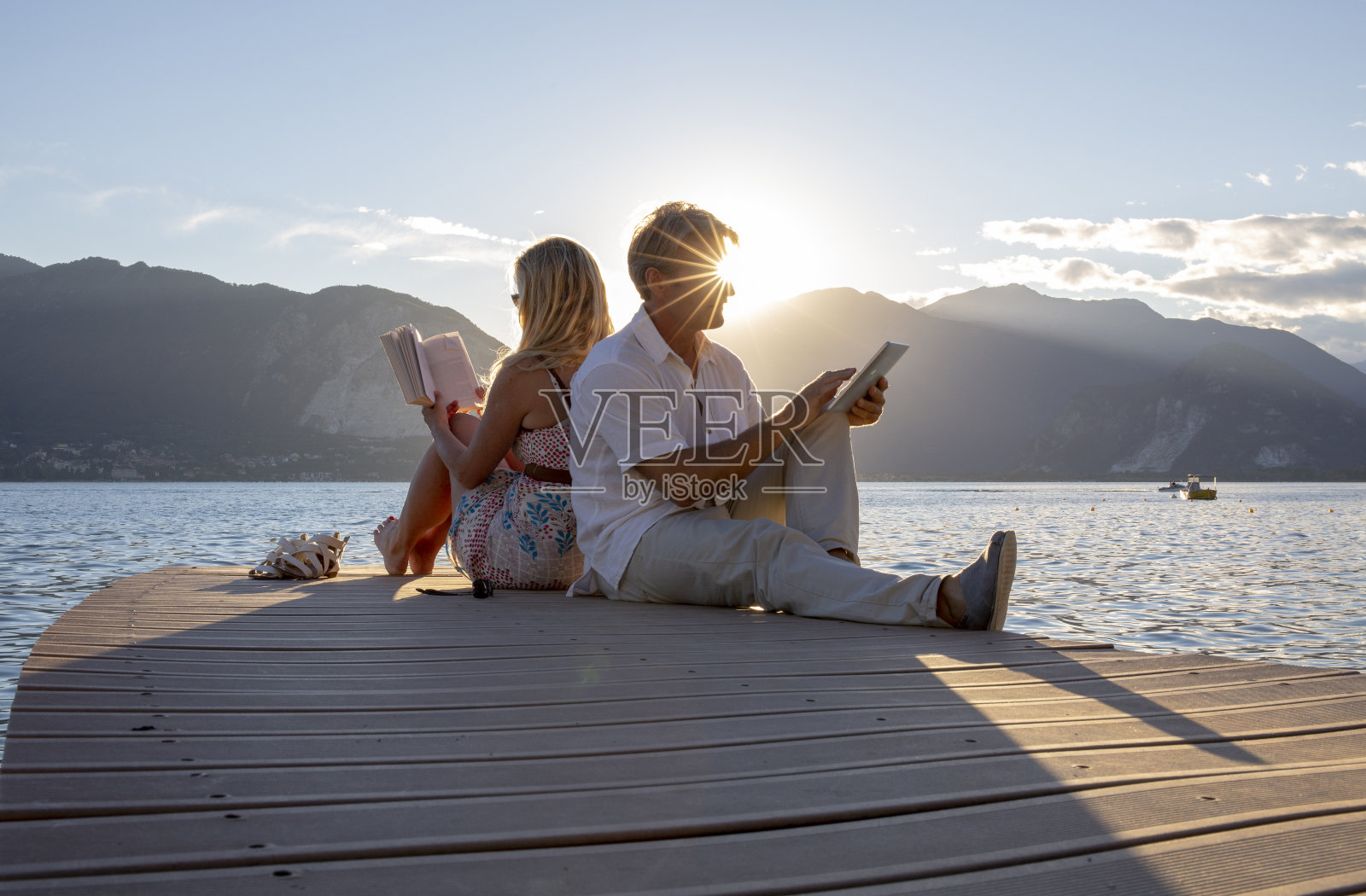 一对夫妇在码头的尽头读过湖,日出照片摄影图片