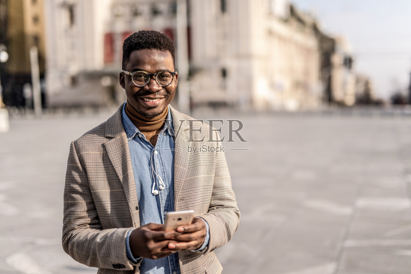 年轻的商人站在城市街道上打电话。照片摄影图片