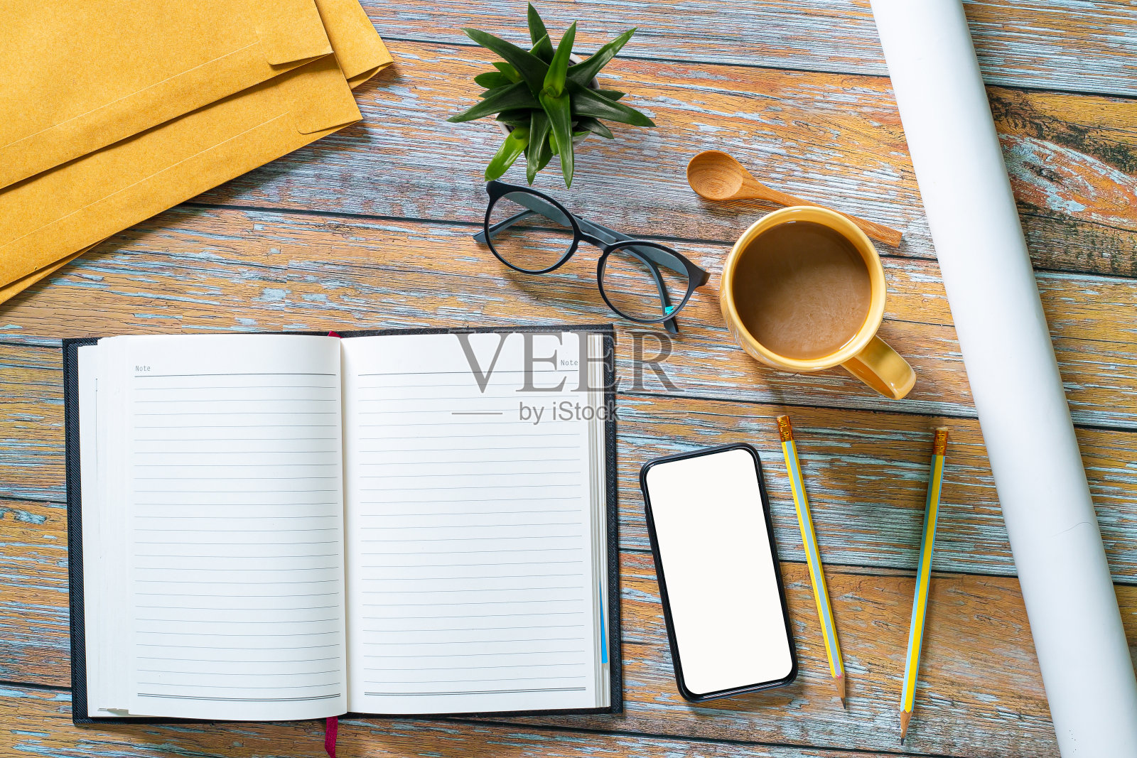 办公室桌子桌上有电脑键盘,咖啡,眼镜和手写在空白笔记本上。俯视图上的木制背景。在早上工作的概念。照片摄影图片