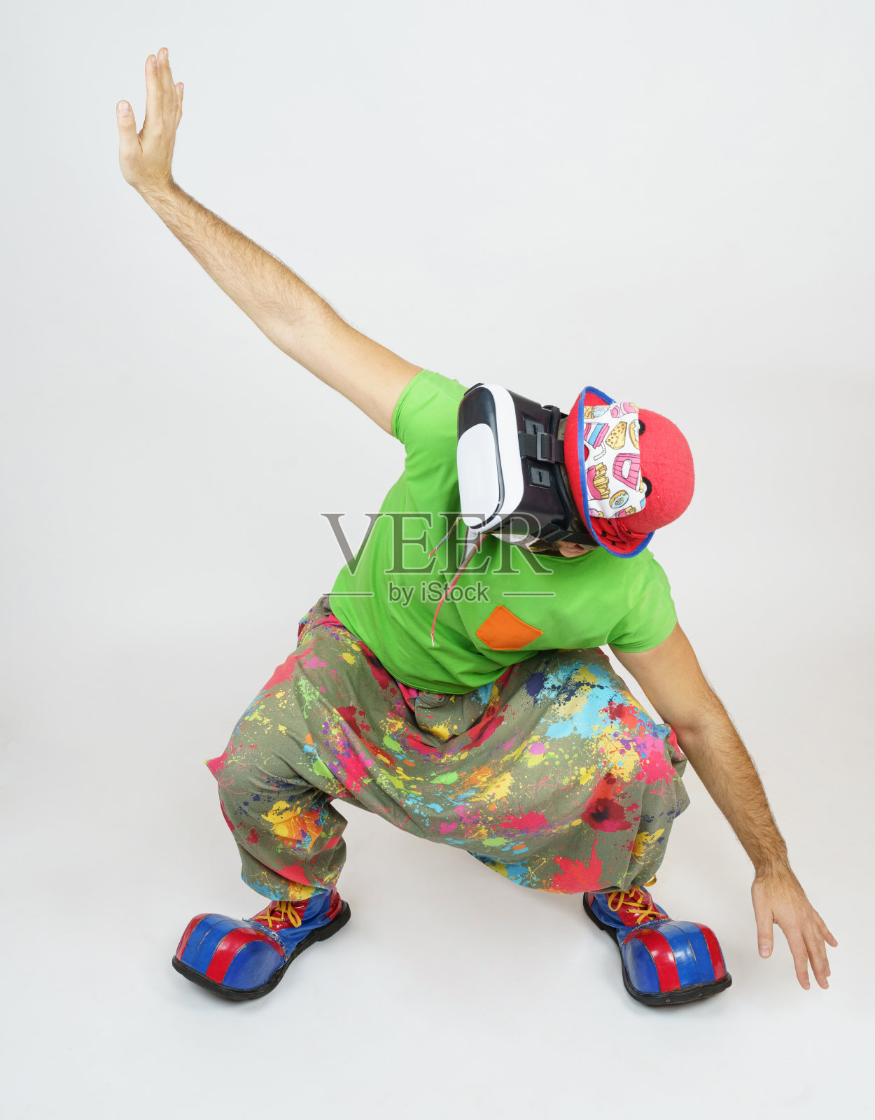 小丑在玩,他的头上戴着虚拟眼镜。孤立在白色照片摄影图片