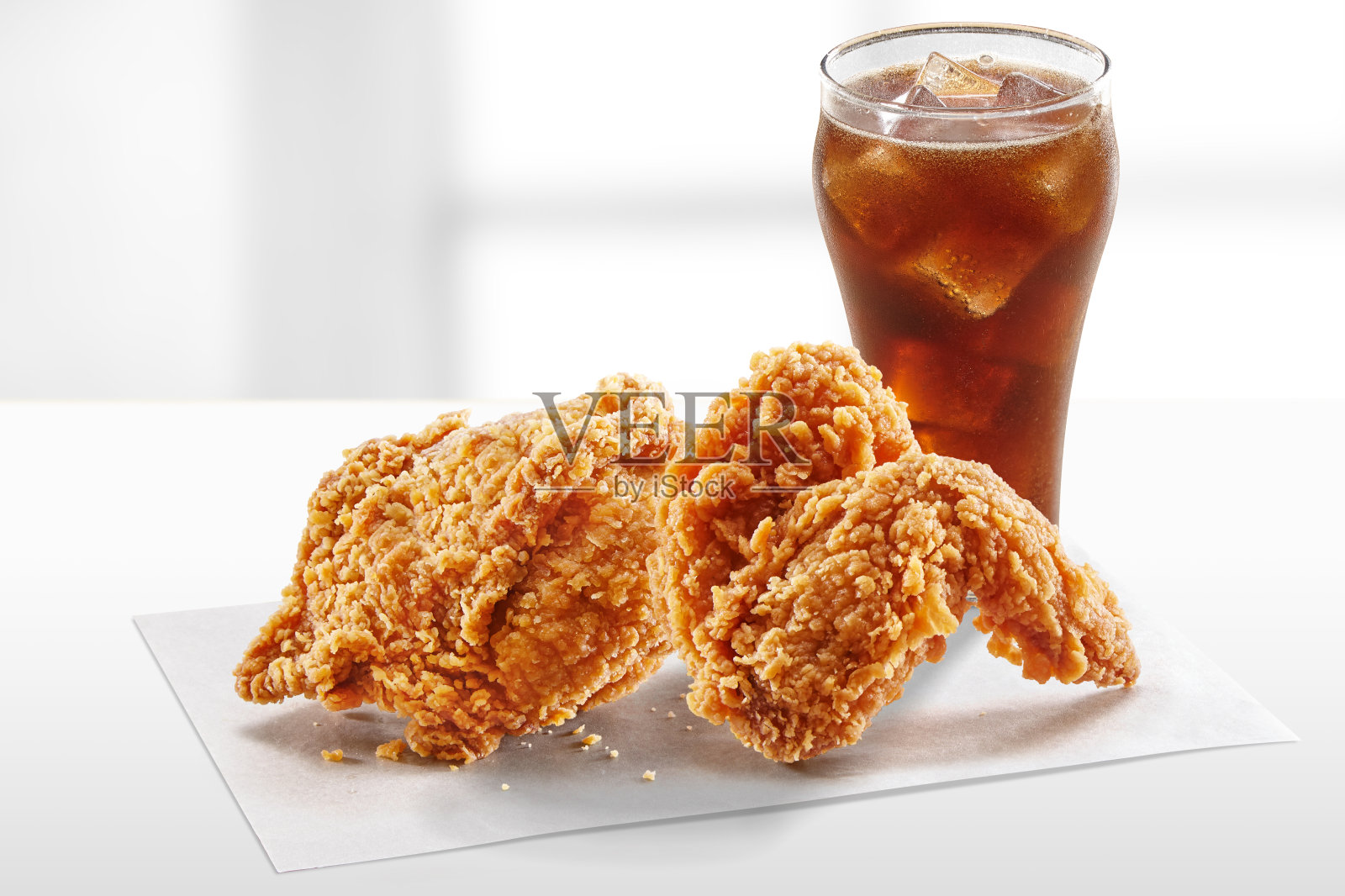 白色的桌子上放着脆脆的肯塔基炸鸡和可乐饮料照片摄影图片