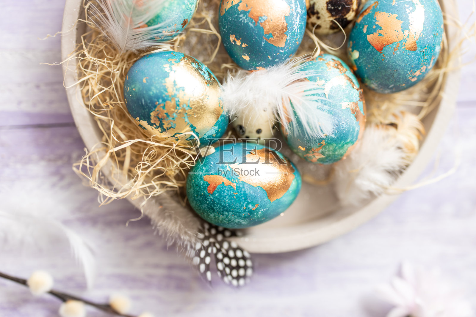 紫色的木头桌子背景上放着蓝色的复活节彩蛋照片摄影图片