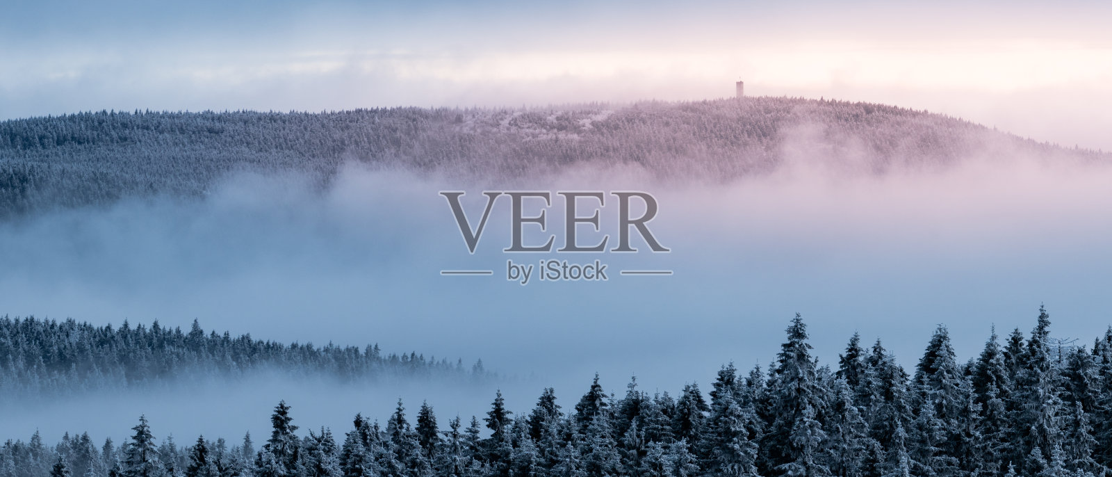 从奥尔利卡观察塔上看到的景色,山上有白雪覆盖的森林和即将到来的雾。照片摄影图片