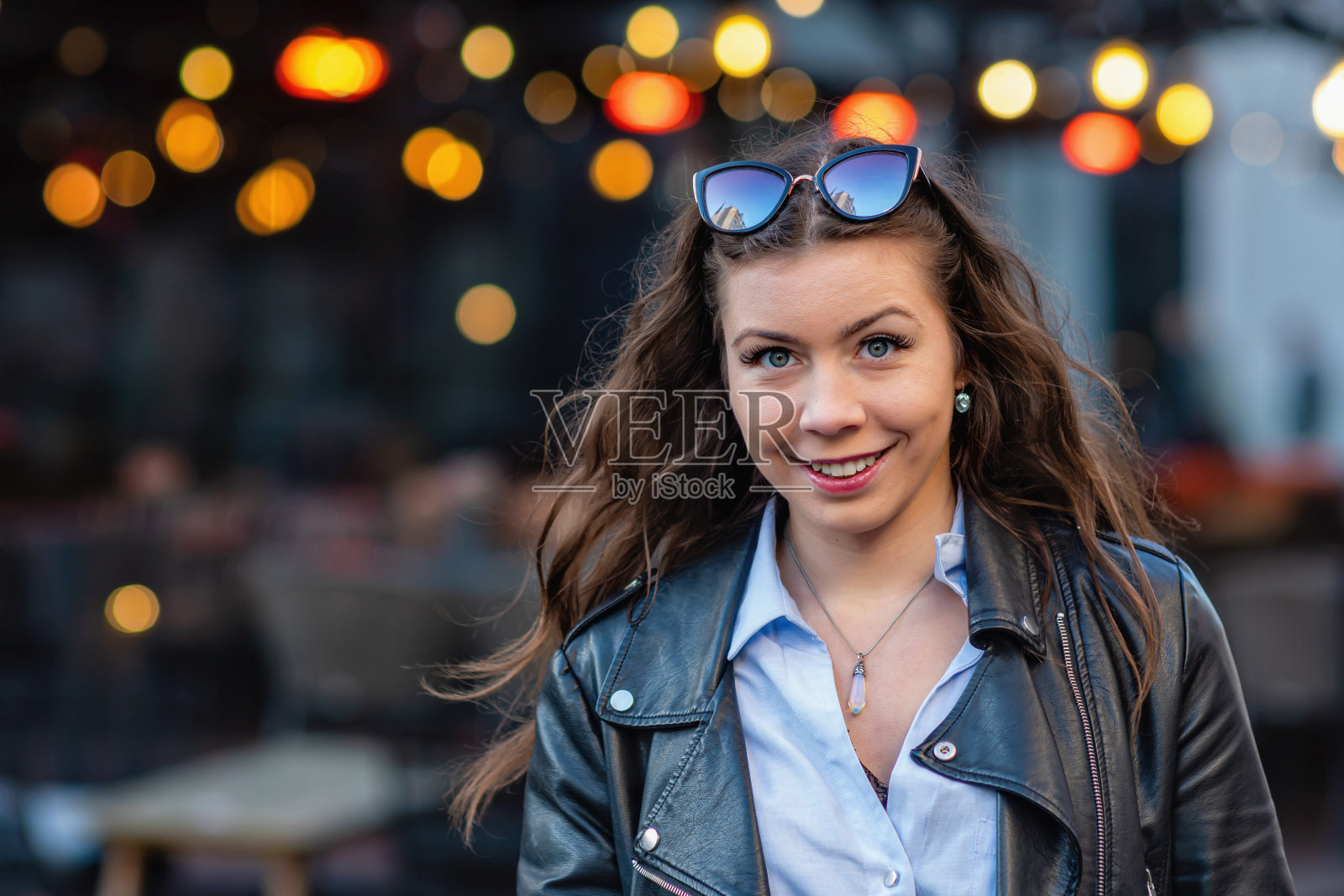 一个可爱和美丽的女人的肖像在散景灯模糊的街道背景照片摄影图片