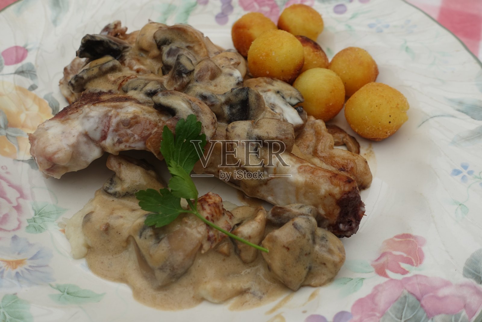 小牛排与奶油和蘑菇一起煮,配以炸土豆,呈榛子状照片摄影图片