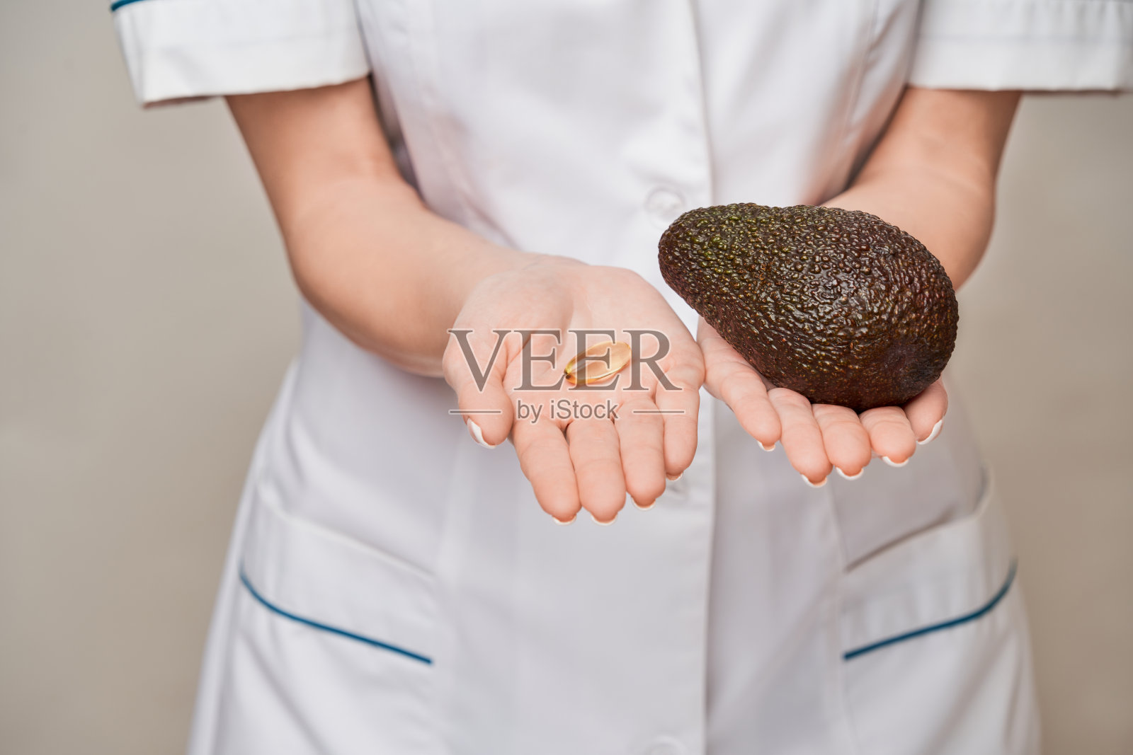 保健和饮食概念-医生营养学家或心脏病学家持有胶囊鱼油维生素D和omega-3脂肪酸和鳄梨照片摄影图片