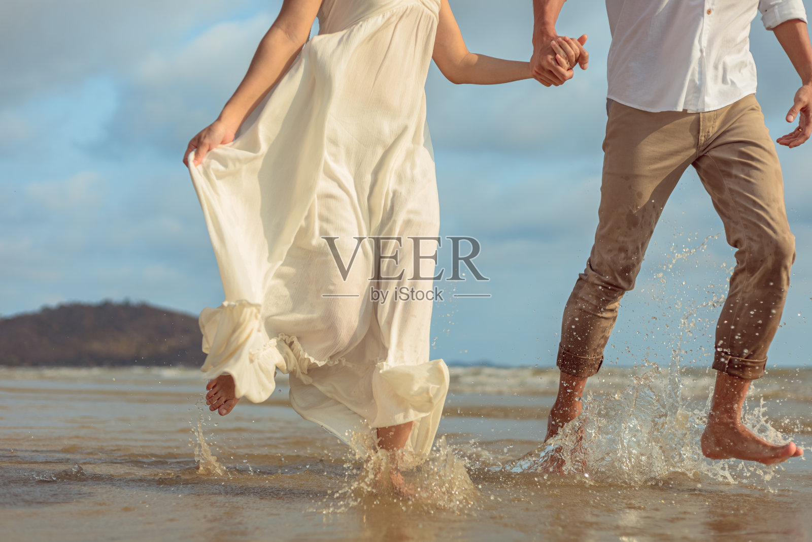 年轻夫妇手牵着手在沙滩上奔跑照片摄影图片
