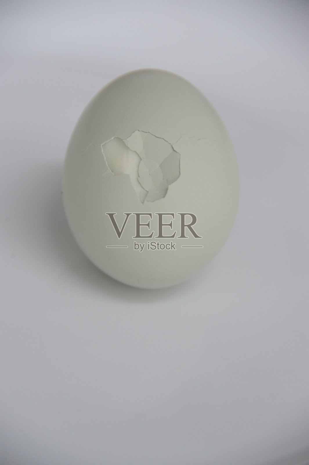 垂直图像的白蓝色煮鸡蛋与裂缝在中心照片摄影图片