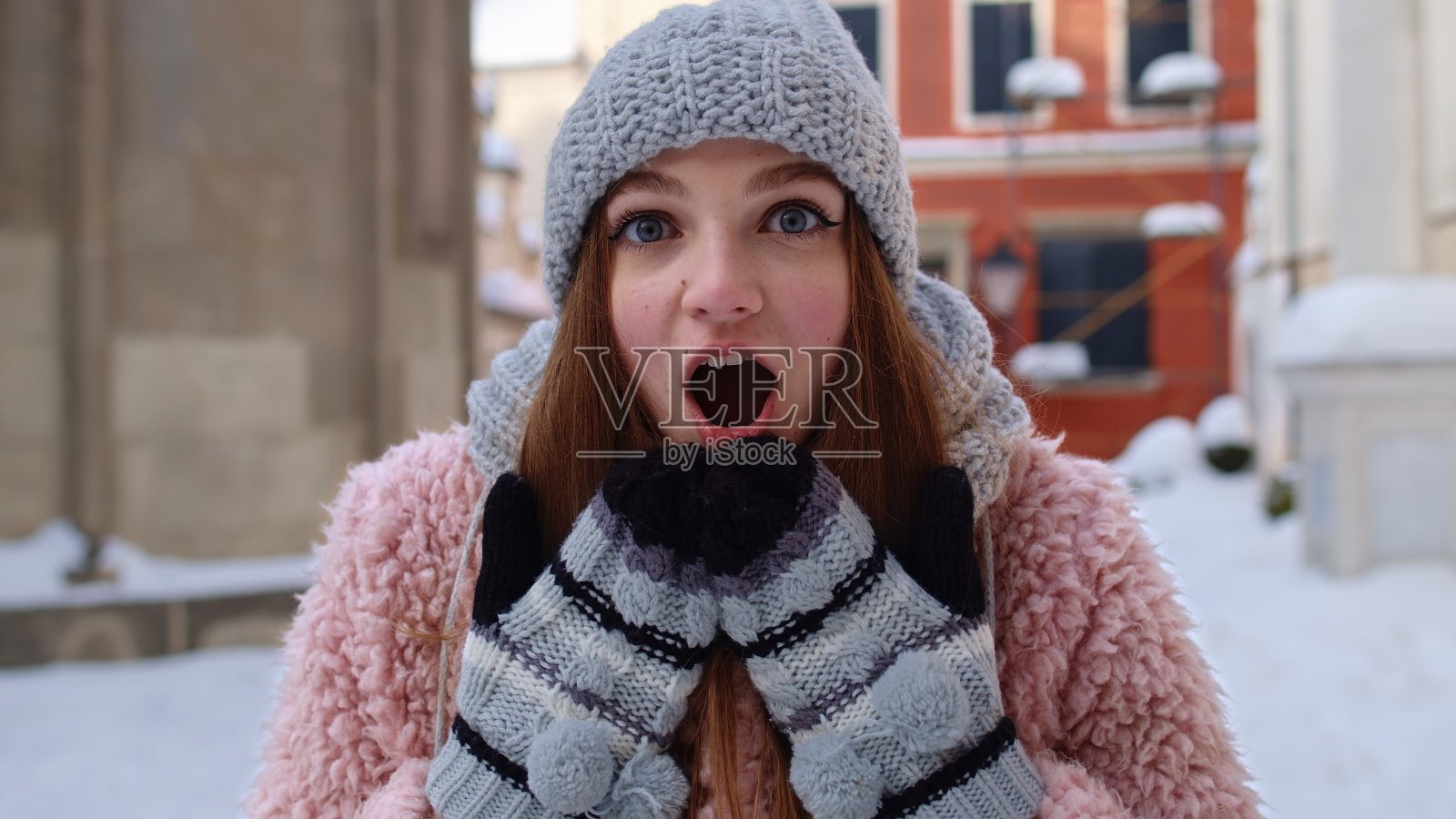 一名兴奋的年轻女子望着镜头,惊讶地张大嘴巴,在城市街道上大喊“哇”照片摄影图片