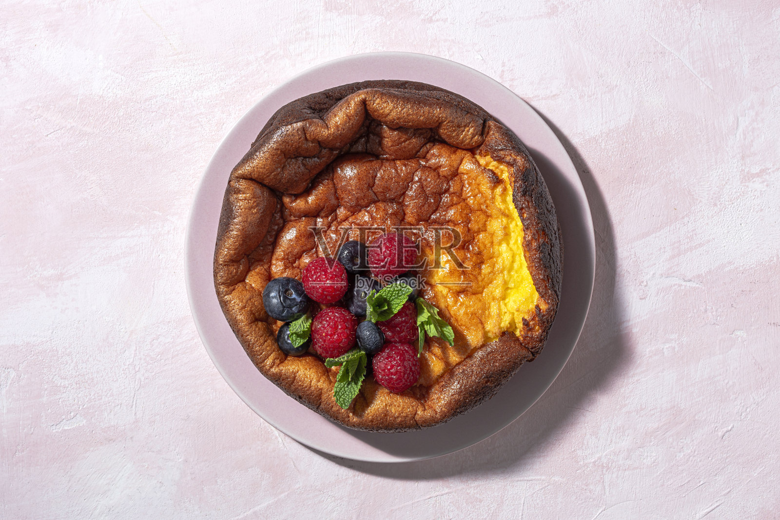 自制芝士蛋糕,上面有蓝莓、醋栗、草莓和薄荷叶。平躺照片摄影图片