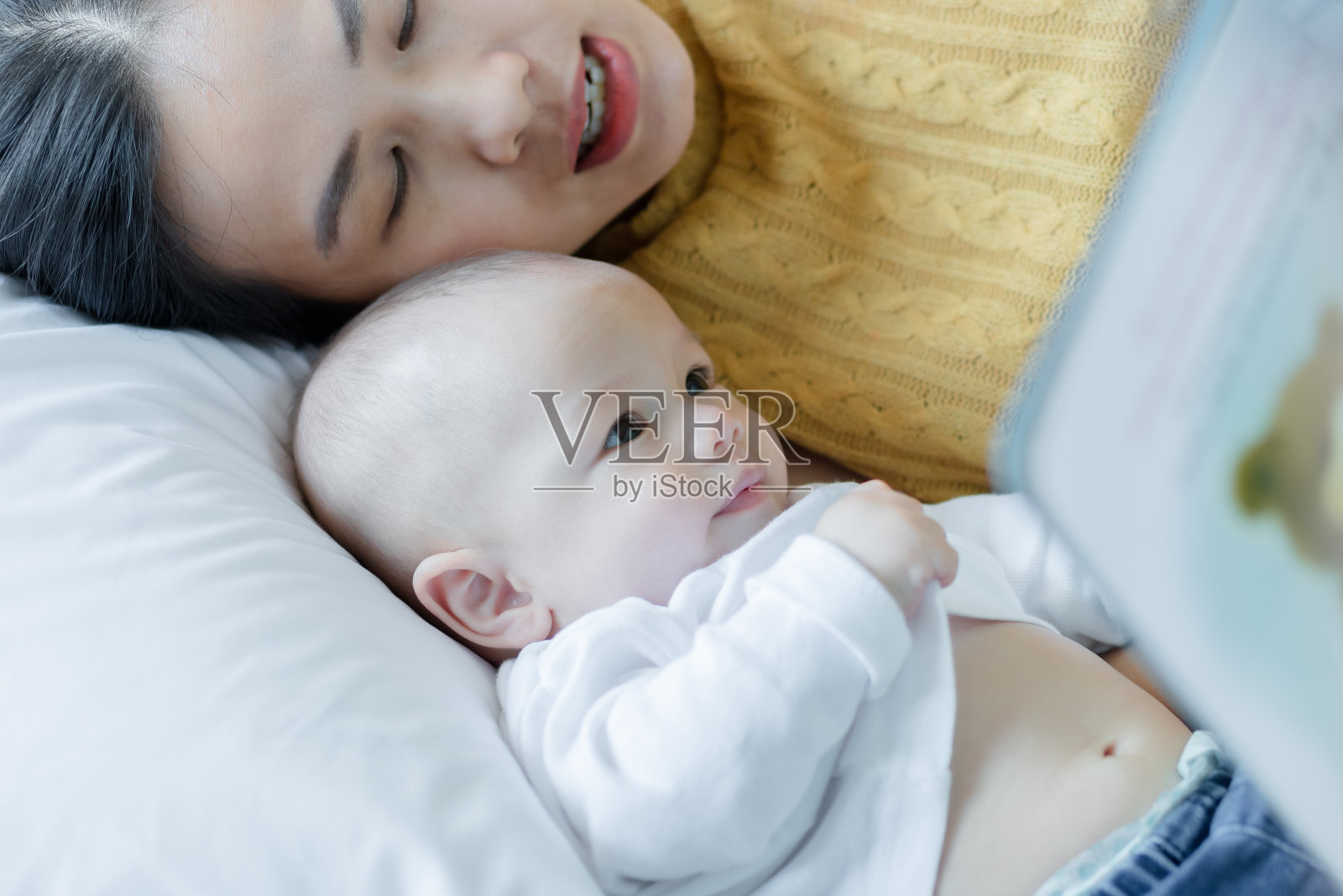 妈妈和她的儿子在睡觉前在床上看书。家庭故事的概念。照片摄影图片